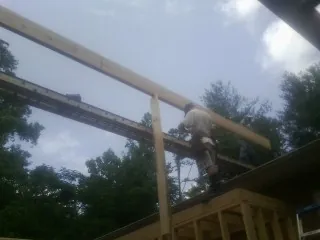 Carpenter setting a ridge beam over a new addition frame — Ice Dam Removal by Roofing Brothers in Bringhurst