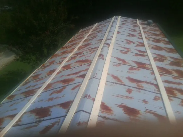 Rusted metal roof panels with new wood purlins before replacement — Storm Damage Roof Repair in Bringhurst by Roofing Brothers