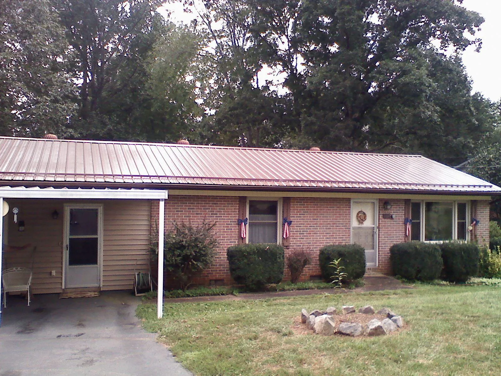 Bronze metal roof and carport on a brick ranch home — Roof Repair work by our crew in Bringhurst